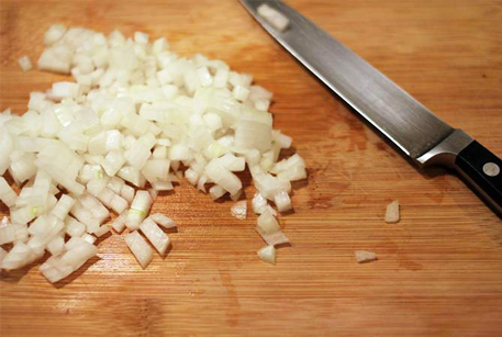 Мелко нарежьте лук для рецепта домашней тушенки из говядины